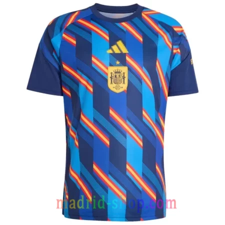 Camiseta Prepartido España 2026 azul con diseño geométrico en zigzag rojo y amarillo.