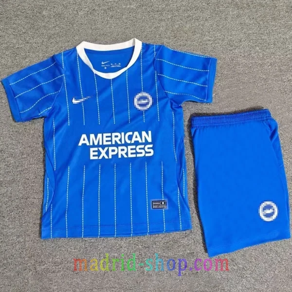Camiseta Brighton Primera Equipación 2026-27 Niño Camiseta Brighton Primera Equipación 2026-27 Niño conjunto infantil azul con rayas blancas y pantalón corto.