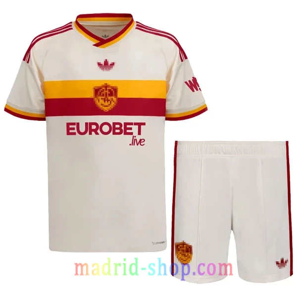 Camiseta AS Roma Niño Segunda Equipación 2026-27 Camiseta AS Roma Segunda Equipación 2026-27 Niño conjunto infantil ecru con pantalón corto.